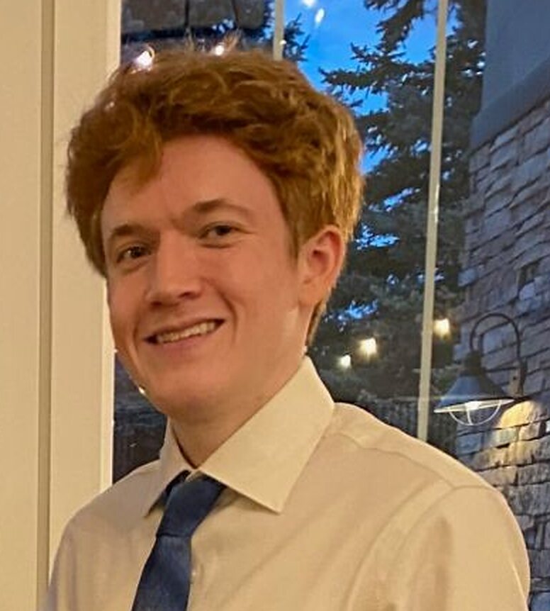 Noah Laratta, smiling, in a white shirt and blue tie